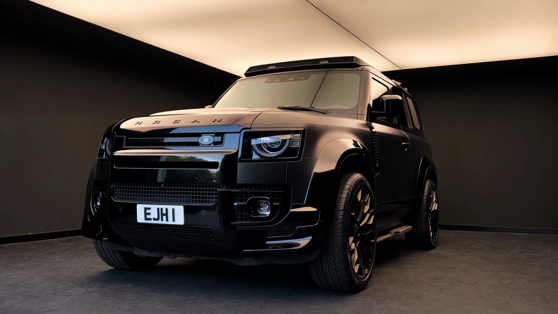 Black Urban Defender with crisp reflections in a softly lit detailing studio